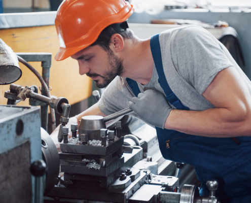 professional engineer metalworker operating CNC milling machine