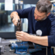 Professional worker working on a steel piece with hammer in a metal factory workshop